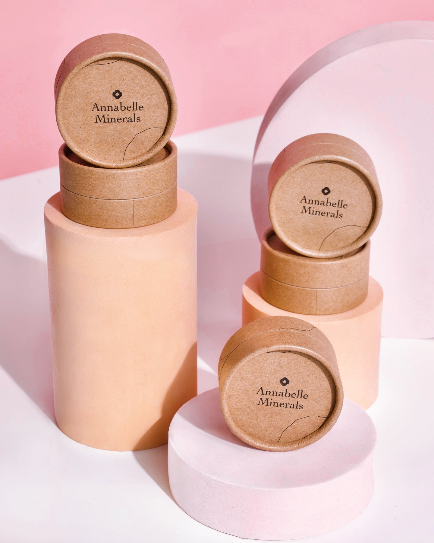 Papierowe okrągłe refille Annabelle Minerals na cylindrycznych podstawach na różowym tle