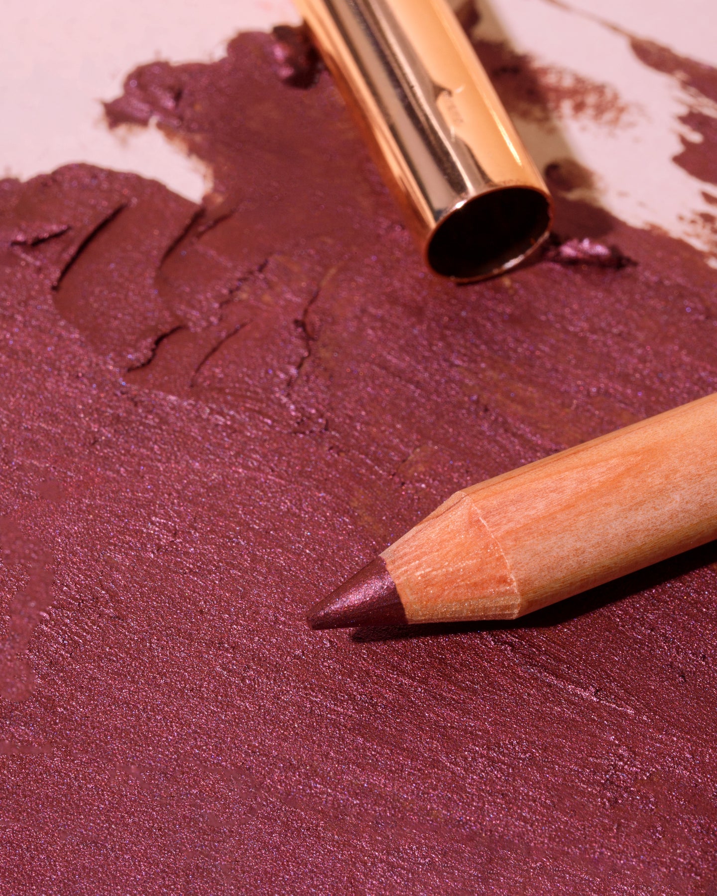 Wiśniowa kredka do oczu Cherry Annabelle Minerals na tle swatcha koloru