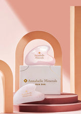 Różowe kwarcowe kamienie gua sha na tle pastelowych kolorów i geometrycznych kształtów