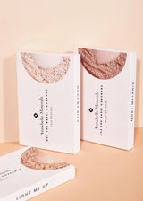 Trzy pudełka mini kosmetyków Annabelle Minerals w minimalistycznym designie na delikatnym brzoskwiniowym tle